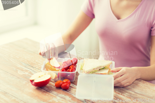 Image of close up of woman with food in plastic container