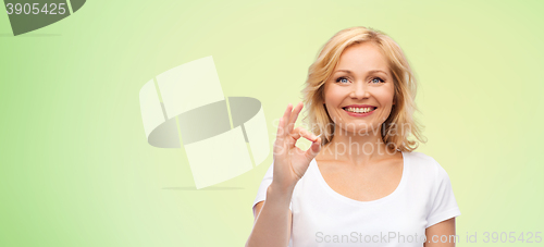 Image of happy woman in white t-shirt showing ok hand sign