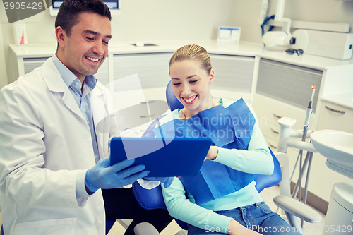 Image of male dentist with tablet pc and woman patient