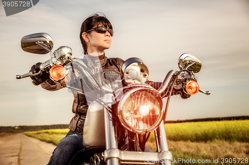 Image of Biker girl sitting on motorcycle