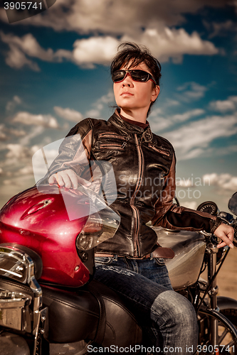 Image of Biker girl sitting on motorcycle