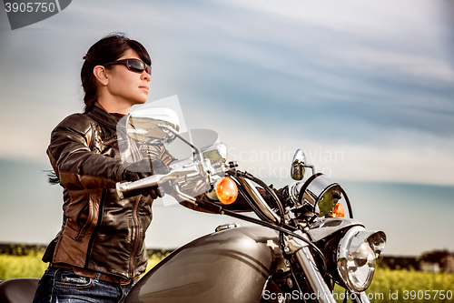 Image of Biker girl sitting on motorcycle