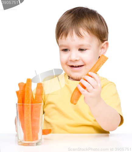 Image of Little boy is eating carrot