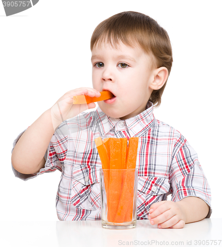 Image of Little boy is eating carrot
