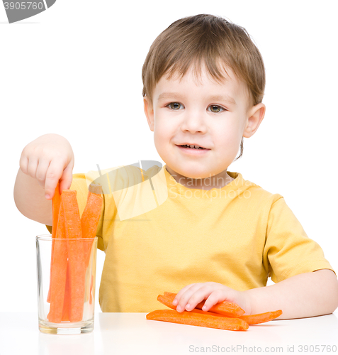 Image of Little boy is eating carrot