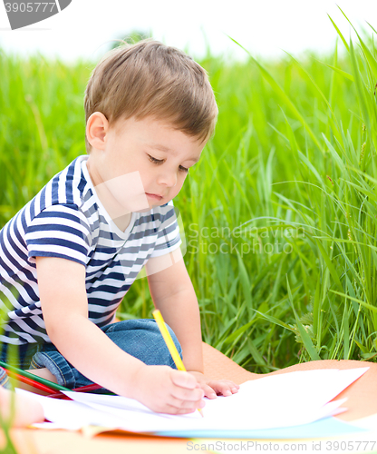 Image of Little boy is playing with pencils