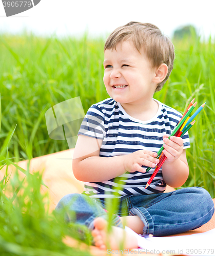 Image of Little boy is playing with pencils