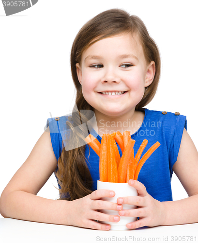 Image of Cute little girl is eating carrot