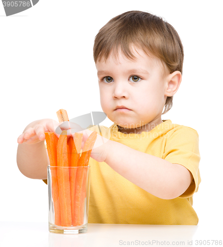 Image of Little boy is eating carrot
