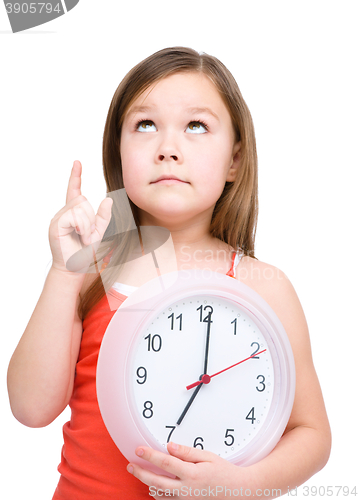 Image of Little girl is holding big clock