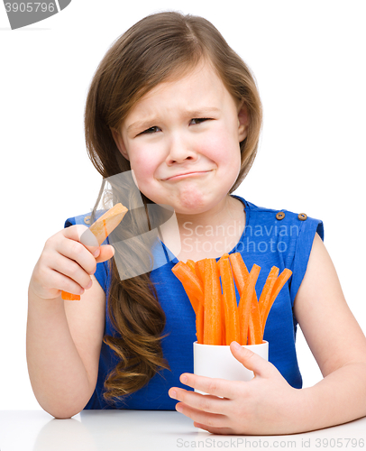 Image of Cute little girl is eating carrot