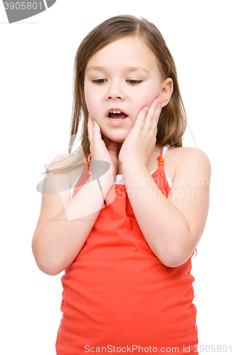 Image of Little girl is holding her face in astonishment