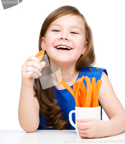 Image of Cute little girl is eating carrot