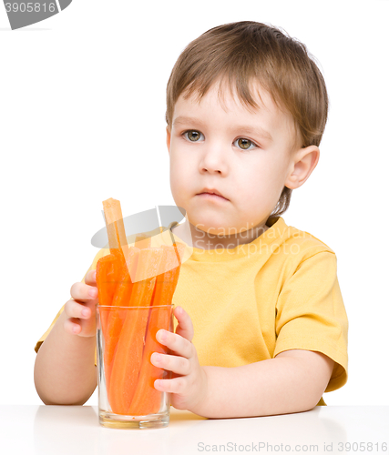 Image of Little boy is eating carrot