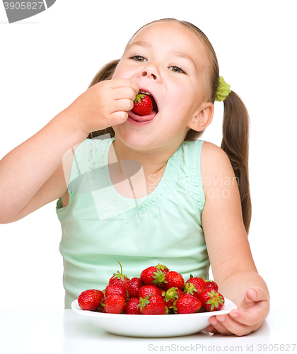 Image of Little girl is eating strawberries