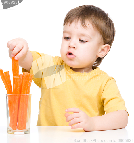 Image of Little boy is eating carrot