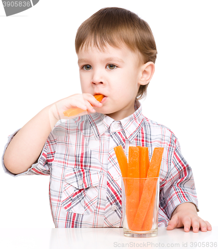 Image of Little boy is eating carrot