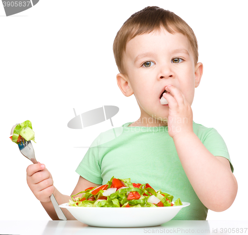 Image of Cute little boy is eating vegetable salad