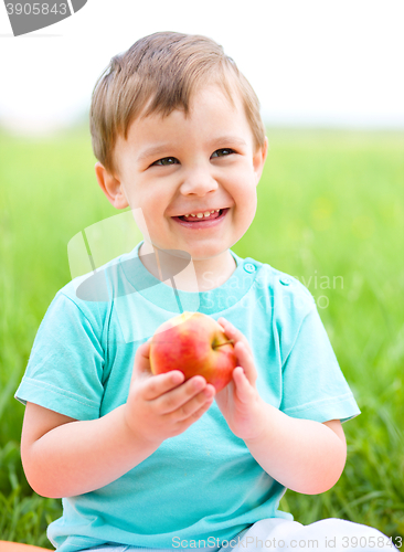 Image of Portrait of a happy little boy with apple