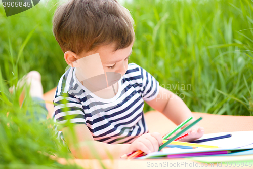 Image of Little boy is playing with pencils
