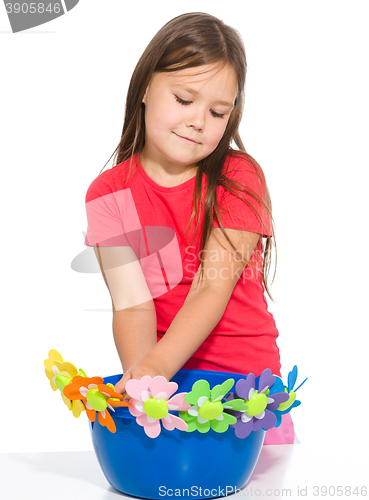 Image of Little girl is playing with flowers
