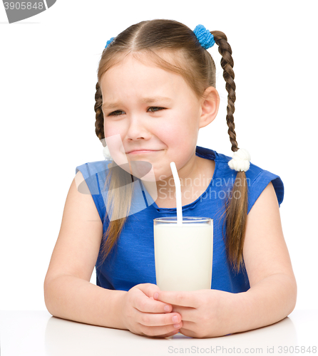 Image of Sad little girl with a glass of milk