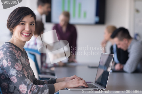 Image of young business woman at office working on laptop with team on me