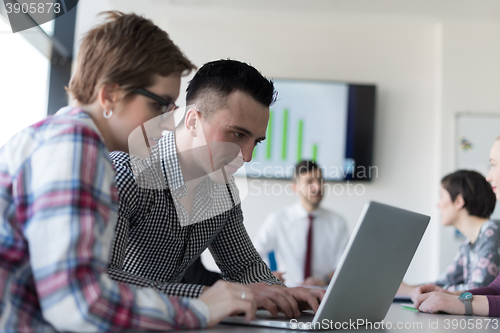 Image of young business couple working on laptop, businesspeople group on