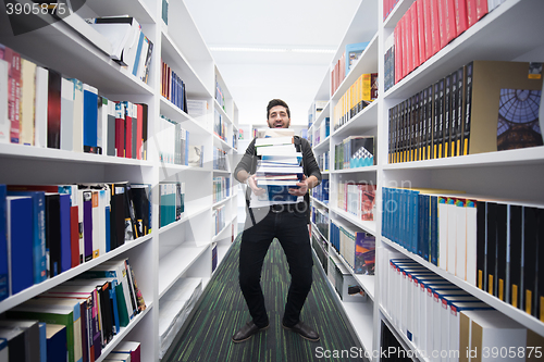 Image of Student holding lot of books in school library