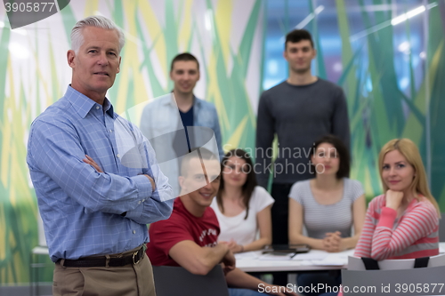 Image of portrait of  teacher with students group in background