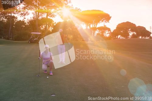 Image of couple on golf course at sunset