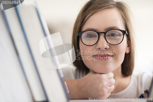 Image of portrait of famale student selecting book to read in library