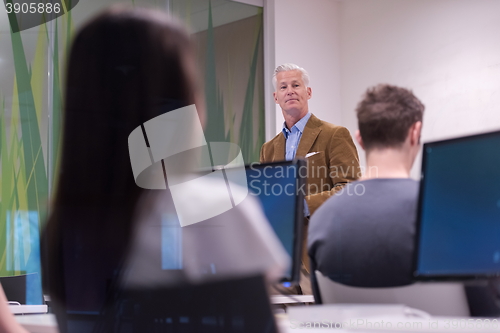 Image of teacher and students in computer lab classroom
