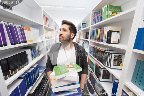 Image of Student holding lot of books in school library