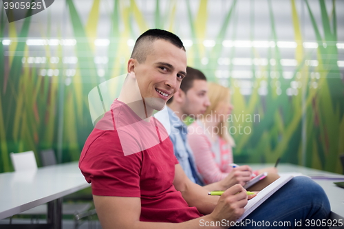 Image of male student taking notes in classroom