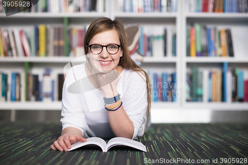 Image of female student study in library, using tablet and searching for 