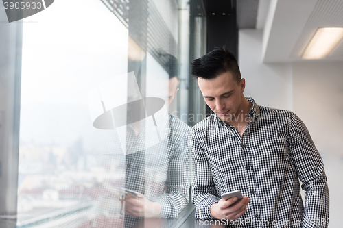 Image of young business man using smart phone at office