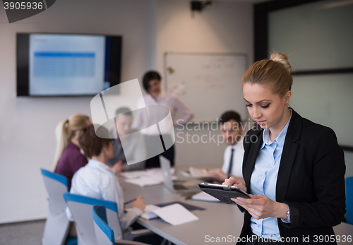 Image of business woman working on tablet at meeting room