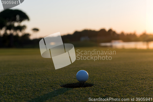 Image of golf ball on edge of  the hole