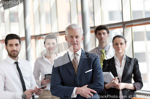 Image of portrait of senior businessman as leader  with group of people i