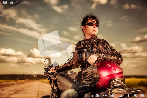 Image of Biker girl sitting on motorcycle