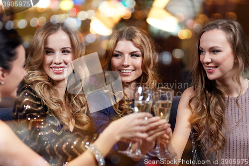 Image of happy women with champagne glasses at night club