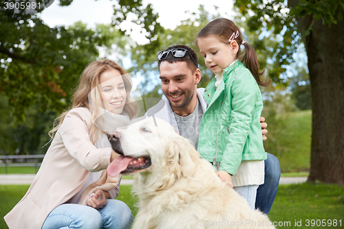 Image of happy family with labrador retriever dog in park