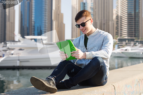 Image of happy young man with tablet pc over city port