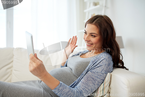 Image of happy pregnant woman with tablet pc at home