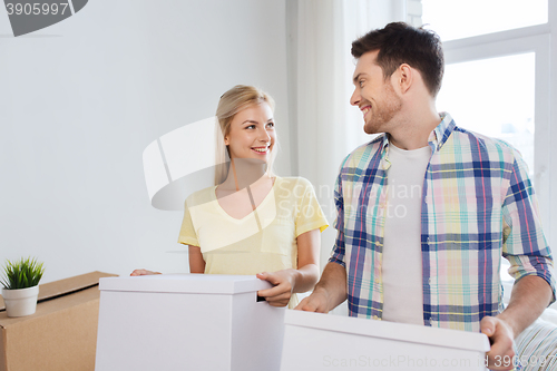 Image of smiling couple with big boxes moving to new home