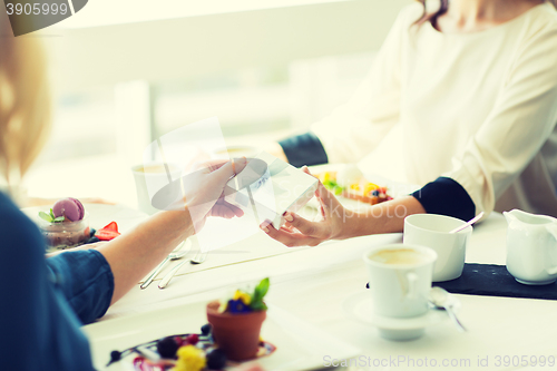 Image of close up of women giving present at restaurant