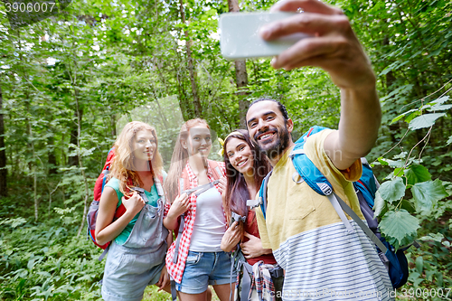 Image of friends with backpack taking selfie by smartphone