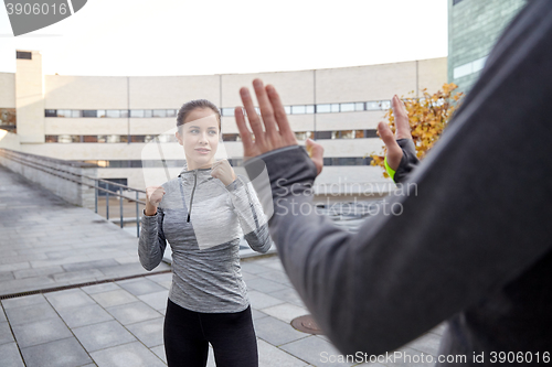 Image of woman with trainer working out self defense strike