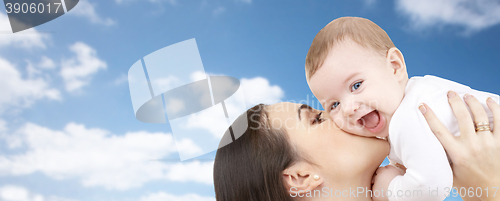 Image of happy mother kissing her baby over blue sky